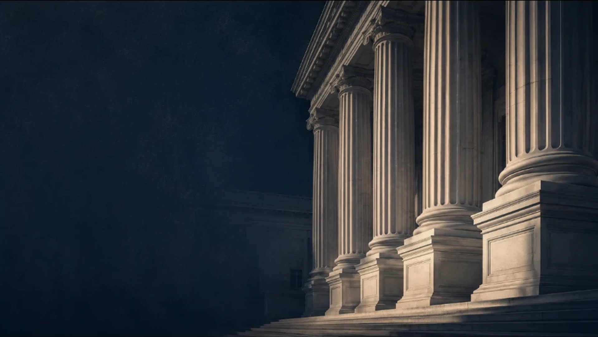 Neoclassical federal courthouse facade with marble columns in low light